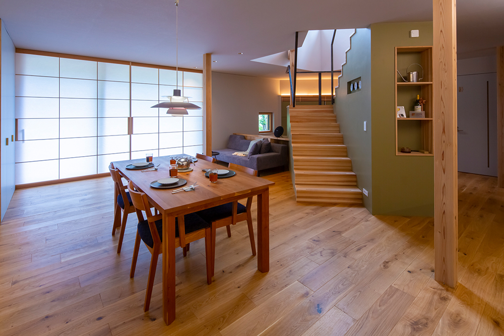 Wohn-Esszimmer in Japan mit grünen Wänden und Holzfußboden